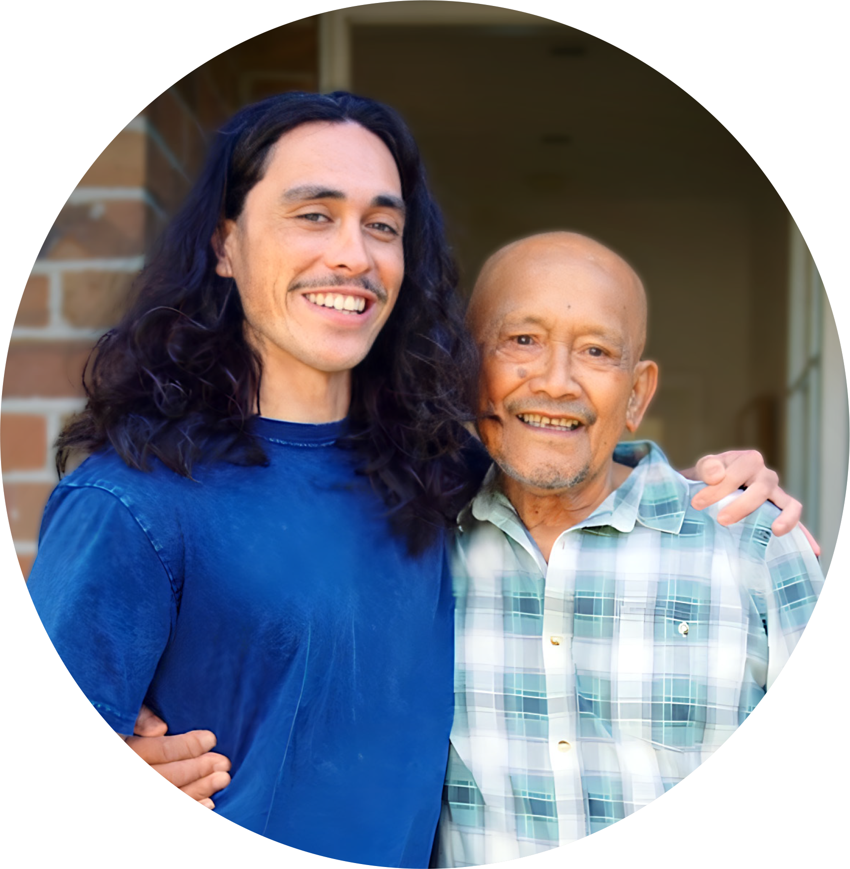 A young 20 something man proudly stands with his arm around his granddad.