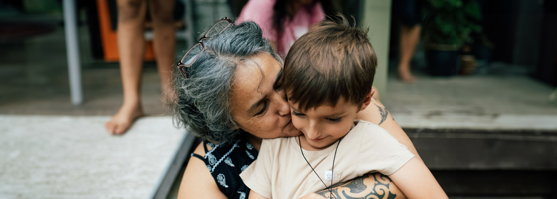 Grandma is giving her favourite grandson a kiss on the cheek.