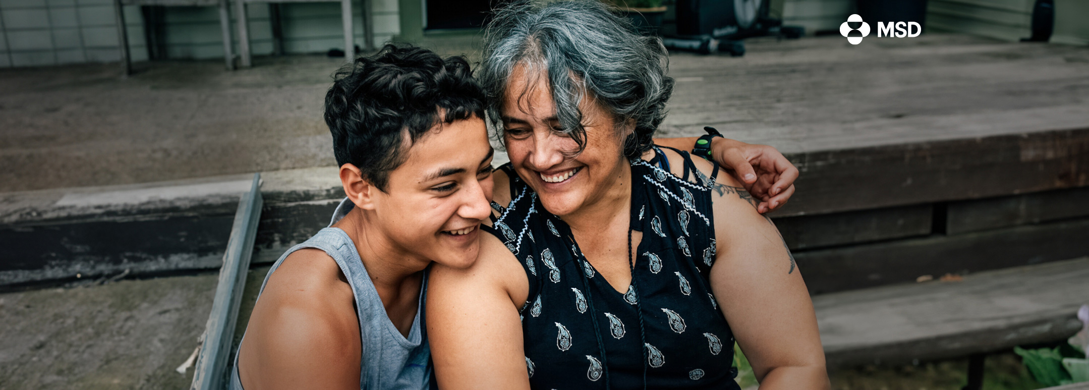 A teenage boy enjoys a laugh with his grandma.